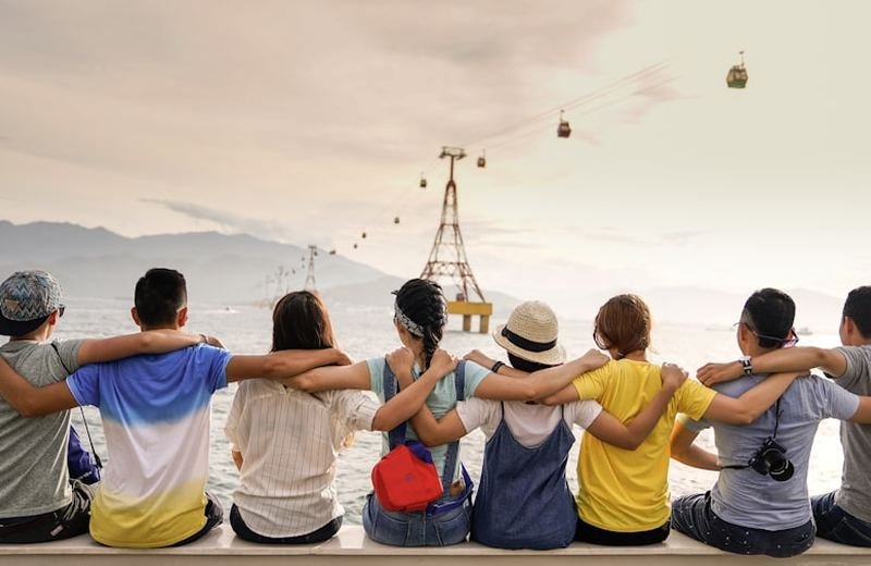 Friends with arms around each other, sitting together